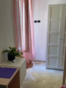 une chambre avec un rideau rose et une porte dans l'établissement B&B Il Corallo, à Terracine
