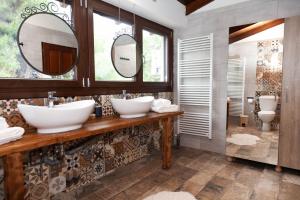 uma casa de banho com dois lavatórios e dois espelhos em Villa Alex em Agios Georgios