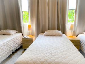 1 dormitorio con 2 camas y 2 ventanas en Casa-Lucy, en Guatemala