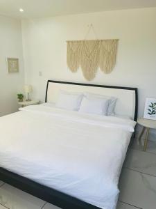 a large white bed with white sheets and pillows at Casa Blanca Beachhouse - walking distance beach in Tamarindo