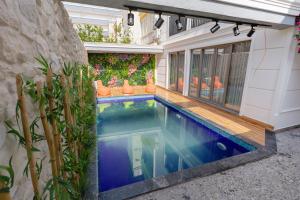 una piscina en el patio trasero de una casa con plantas en Mrt Suites Lara, en Antalya