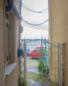 a red car is parked in a parking lot at Deppy's Two-storey House in Corfu