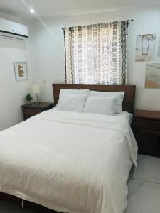 a bedroom with a large white bed and a window at Casa Blanca Beachhouse - walking distance beach in Tamarindo