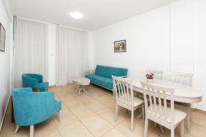 uma sala de estar com uma mesa e cadeiras e um sofá em Flora Hotel Apartments em Protaras
