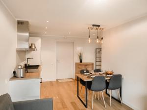a kitchen and dining room with a table and chairs at Beautiful Seaside apartement Albatross 24 in Ķesterciems
