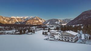 einen Luftblick auf ein Resort mit schneebedeckten Bergen in der Unterkunft Hotel Landhaus Tirolerherz in Sankt Ulrich am Pillersee