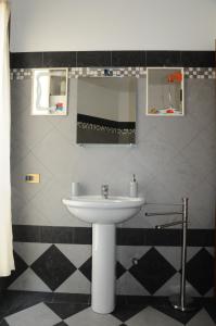 La salle de bains est pourvue d'un lavabo et d'un miroir. dans l'établissement ADRIA ART APARTMENTS 1, à Adria