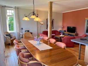 uma sala de estar com uma mesa de madeira e cadeiras vermelhas em Landgut Oberhof em Klütz