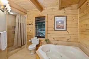 a bathroom with a white tub and a toilet at Fire And Ice in Blowing Rock +32 photos
