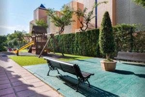 a park with a park bench and a playground at Las Arenas-Islantilla-Huelva in Islantilla