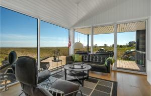 a living room with a couch and chairs and large windows at Amazing Home In rsted With House Sea View in Kare