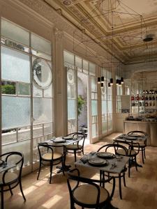 a restaurant with tables and chairs in a room with windows at Artemisia Domus - Giardino in Naples