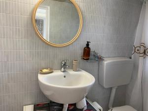 W łazience znajduje się umywalka, lustro i toaleta. w obiekcie Rifugio tra gli ulivi w mieście Marina di Ragusa