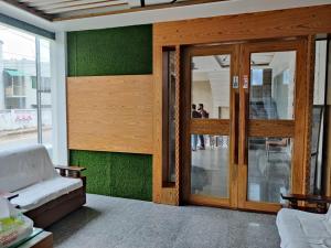 a living room with green walls and a wooden door at Hotel Hill Ambassador in Rāngāmāti