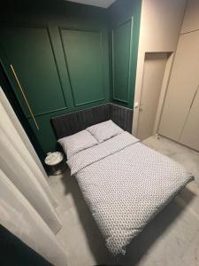 a bed in a room with a green wall at CoCo Elite Apartments Zator in Zator