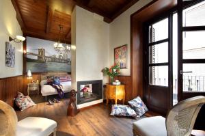 a living room with a fireplace and a bedroom at Casa Palacete 1822 in Granada