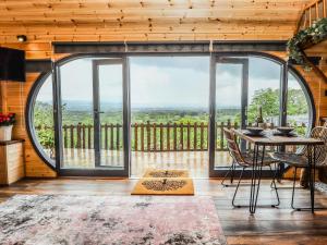 Habitación con mesa, sillas y ventana grande. en Offas Dyke Escape, en St Asaph