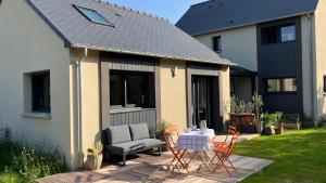 a patio with a couch and a table and chairs at Ker Neizh Cancale, Cottage Baie de Cancale GR34 in Cancale