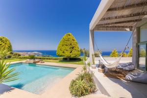 a villa with a swimming pool with a view of the ocean at Mama La Roosa Luxury Retreat in Agia Pelagia