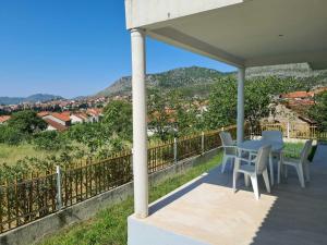a porch with a table and chairs and a view at Vizura in Trebinje