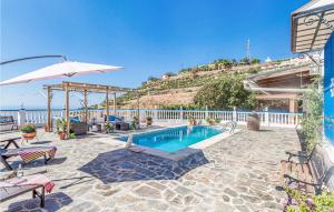 a house with a swimming pool and an umbrella at Nice Home In Velilla-Taramay With Wifi in Taramay