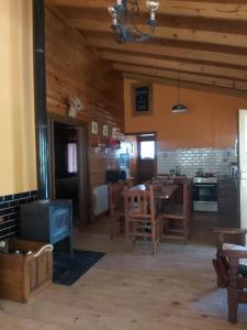 eine Küche und ein Esszimmer mit einem Tisch und einem Herd in der Unterkunft La Peninsula Cabaña in San Carlos de Bariloche