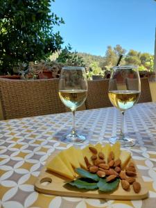 a table with two glasses of white wine and nuts at Brna Three-room apartment near the beach-Zen in Brna