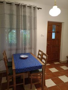 uma sala de jantar com uma mesa e cadeiras e uma janela em Cserépkályhás Vendégház em Panyola