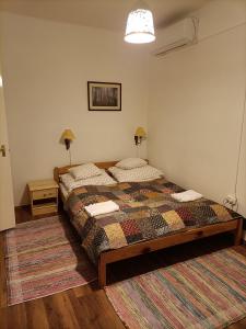 um quarto com uma cama e um tapete em Cserépkályhás Vendégház em Panyola