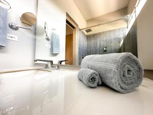 a bathroom with a sink and a towel at Hotel Arena Suites in Bogotá