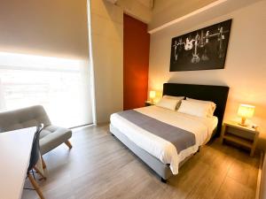 Hotel Arena Suites في بوغوتا: غرفة نوم فيها سرير وكرسي