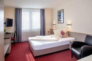 Łóżko lub łóżka w pokoju w obiekcie Sporthotel Öhringen