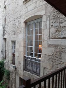 uma janela de um edifício de pedra com uma varanda em Le studio de la Clarté em Périgueux