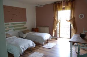 een slaapkamer met 2 bedden en een groot raam bij Un angolo di Paradiso in Ozzano Monferrato