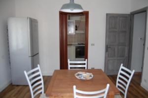 een keuken met een houten tafel met stoelen en een koelkast bij Un angolo di Paradiso in Ozzano Monferrato