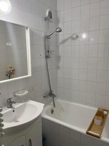 W łazience znajduje się wanna, umywalka i prysznic. w obiekcie Kalmár Apartman w mieście Veszprém