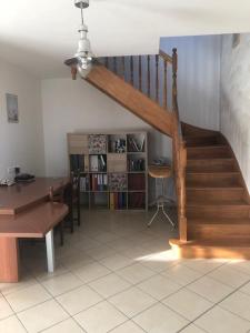 a staircase in a room with a table and a desk at Maison près de Bon repos in Laniscat