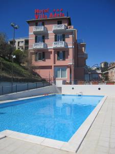 un hotel con piscina frente a un edificio en Hotel Villa Adele, en Celle Ligure