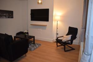 a living room with two chairs and a flat screen tv at Forest Gate Haven in London