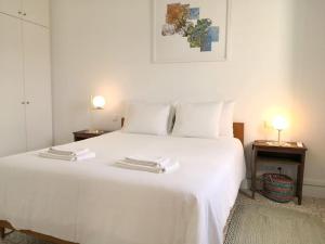 a white bed with two towels on top of it at Eco-Villa Monte Do Barrocalinho in Loulé