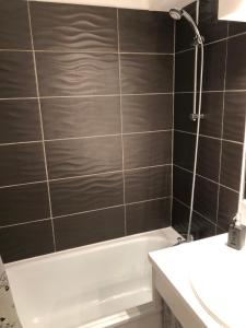 a bathroom with a white tub and a sink at Studio Puy saint vincent 1600 in Les Prés