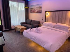 a bedroom with a large white bed and a couch at TheWaterfrontLodges in Coventry