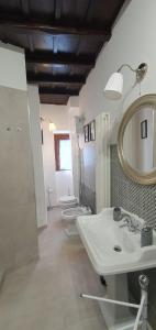 a bathroom with two sinks and a mirror and two toilets at la Dimora del Borgo in Fiumicino