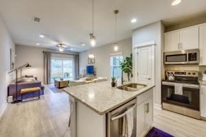 a kitchen with a counter top and a living room at Pet-Friendly Townhome, 1 Mi to Southbank Riverwalk in Jacksonville