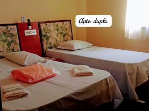 サンパウロにあるHospedaria Monumentoのベッド2台が隣同士に設置された部屋です。