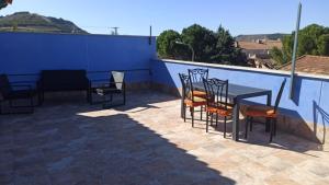 una mesa y sillas en un patio con una pared azul en Las 3 Golondrinas, en Peñafiel