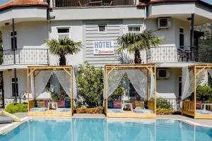 a hotel with a pool in front of a building at Bybassios Hotel in Orhaniye