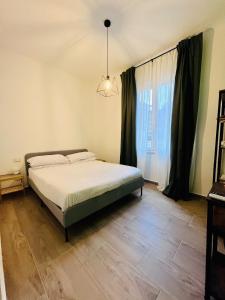 a bedroom with a bed and a large window at A Pisa con amore in Pisa