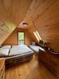 ein Schlafzimmer mit einem Bett in einer Holzhütte in der Unterkunft Chata s luxusním výhledem a bazénem in Kunčice pod Ondřejníkem