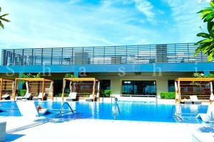 une grande piscine avec des chaises et un bâtiment dans l'établissement Paradise on the Island - Luxurious Seaview Apartment @DubaiCreekHarbour, à Dubaï